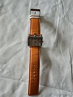 Front view of Tokyo Boy wristwatch showing dial and orange strap