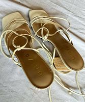 Top view of both sandals showing white straps, square toes and gold Unisa branding on footbeds