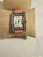 Front view of Bloomingdale's watch showing dial, stone bezel, pink strap
