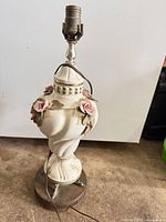 Front view of ceramic lamp showing rose decorations and socket