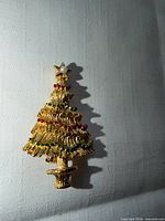 Front view of gold tone Christmas tree brooch pin