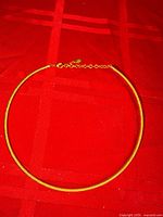 Full view of collar necklace laid flat showing overall shape and extender chain