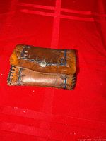 Front view of closed brown leather wallet with blue leaf tooling and snap