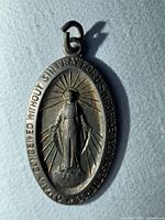 Front view of oval Miraculous Medal pendant showing Mary image and full inscription
