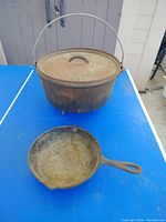 Dutch oven with lid and skillet on table
