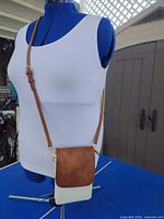 Front view of cream and brown crossbody purse on mannequin