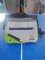 Front view showing Alcott logo, grey panels, green trim, zip pocket