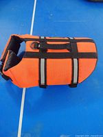 Side view showing orange fabric, reflective strips and brand patch