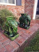 Both ceramic elephant pedestals on brick path