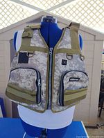 Front view showing digital camo pattern, zip front, cargo pockets, patches, shoulder adjusters