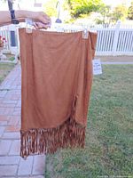 Front view of tan faux suede fringe skirt showing fringe hem