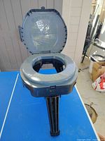 Toilet open showing seat and support legs