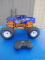 Profile of blue RC monster truck with remote in front