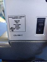 Close-up of specification label showing model CG-590C, voltage and amperage