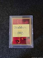 plastic case containing cards with handwritten note Aladdin 1993 on top card