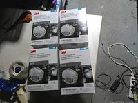 Four sealed boxes of 3M 8210 N95 masks on table