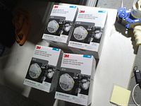 Top-down view of four sealed boxes of 3M 8210 N95 masks on a table