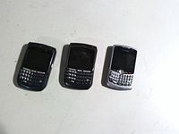 Front view of three BlackBerry smartphones showing keyboards and screens