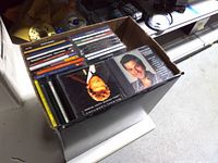 Open box showing rows of CDs with jewel case spines visible