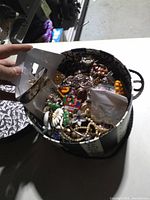 Open round hat box showing assorted costume jewelry pieces