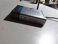 Front view of powered-on D-Link DI-524 router showing LEDs