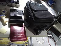 Projector, remote, carrying case, manual folder on table