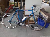 Full view of blue Fuji Palisade bicycle leaning against post