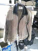 Full view of Gitano tan suede leather jacket on hanger