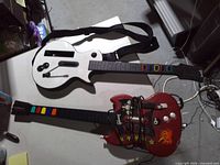 Front view of both guitar controllers showing body designs, fret buttons, and attached strap