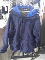 Front view of navy blue Moonstone Gore-Tex raincoat on hanger
