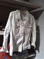 White denim jacket hanging to show front view