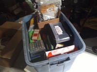 Overall view of plastic tote filled with assorted office supplies