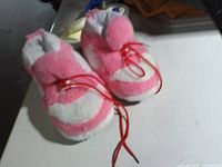 top view showing pink and white plush slippers with red laces