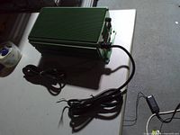 Top and side view of green finned power supply with cords