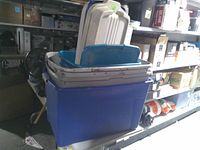 Stacked plastic totes showing blue base tote, teal middle tote, grey shallow totes and multiple lids