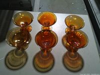 Six amber carnival glass footed cups on table