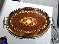 Top view of oval wooden tray showing brass gallery rim and handles
