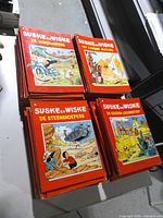 Four sample albums laid on top of stacked lot showing titles and cover art