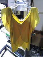 Front view of yellow top on hanger