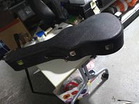 Closed black guitar hardcase on table