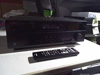 Front view of receiver displaying text, remote placed in front