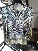 Front view of zebra print sheer top on hanger