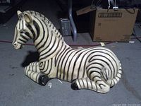 Full view of zebra statue lying on floor