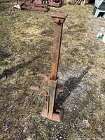 Full view of cast-iron ratchet jack standing upright on ground