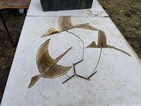 Full view of brass three-bird sculpture on table