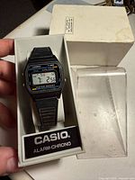 Watch in open plastic display case showing face and branding