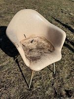 Front view of dirty fiberglass armchair on grass