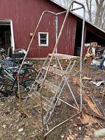 Full view of rolling staircase showing structure, steps and rust