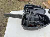 Chainsaw inside open carrying case on table