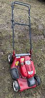 Full view of red Craftsman mower with folded handle on grass